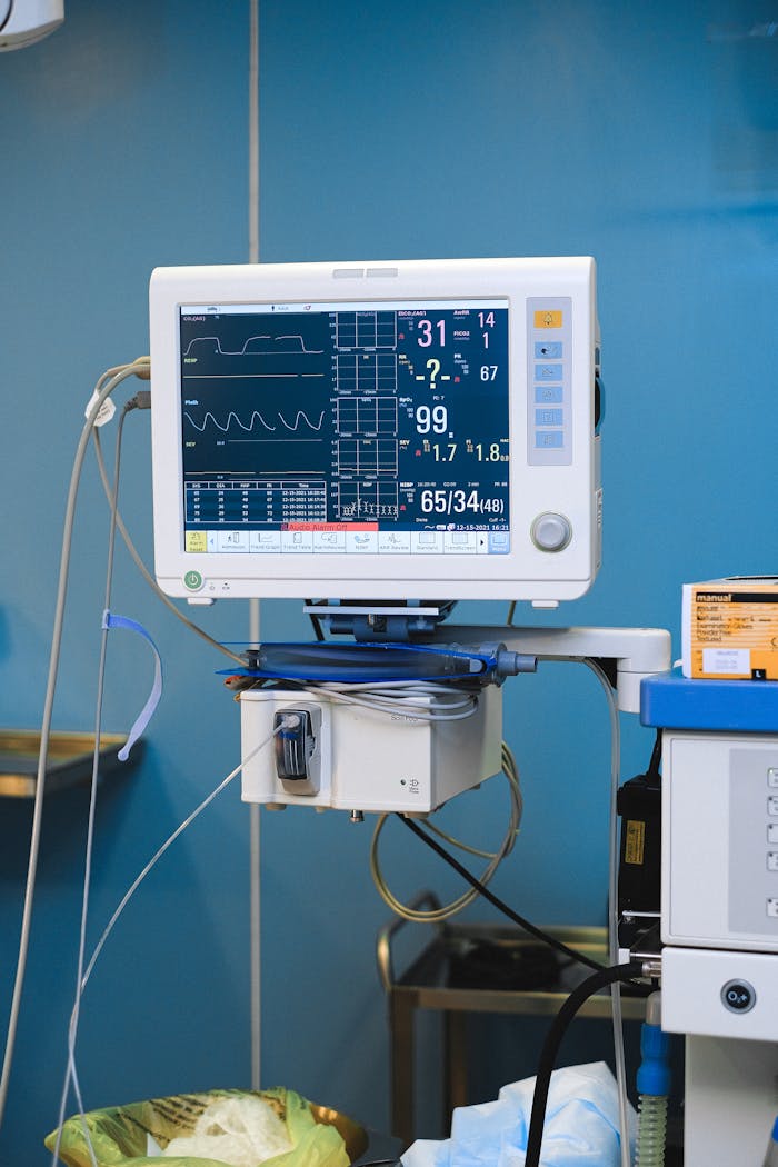 Close-up of a hospital monitor displaying vital signs and heart rate data.